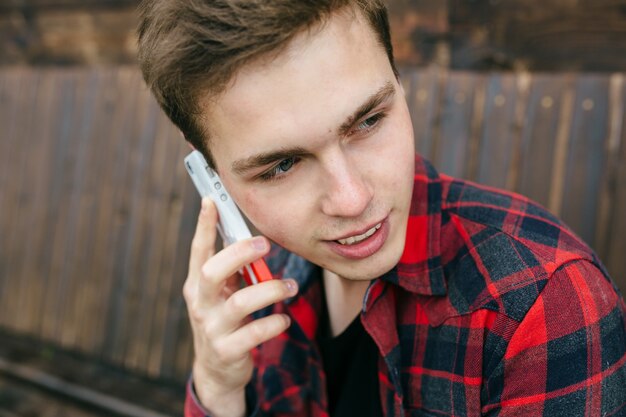 Close-up de cara com camisa xadrez e smartphones