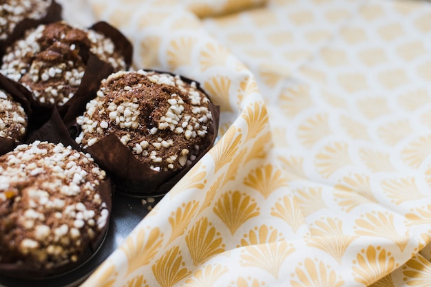 Close-up, de, chocolate, muffins, em, papel marrom, sobre, a, toalha de mesa