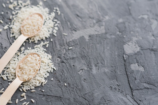 Close-up, de, colher madeira, enchido, com, arroz, sobre, cinzento, cimento, fundo