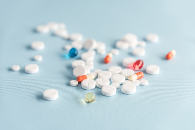 Close-up de comprimidos brancos e cápsulas coloridas