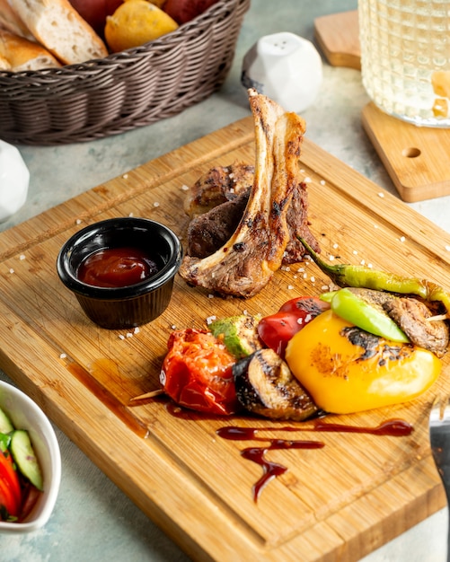 Close-up de costeleta de cordeiro kebab servido com legumes defumados e molho