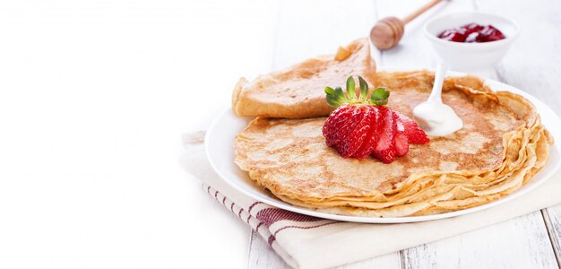 Close-up de crepes com creme e morangos