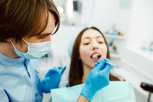 Close-up de dentista examina um paciente