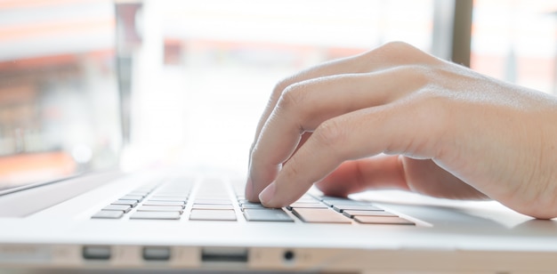 Close up de digitação mão da mulher de negócios no teclado do portátil