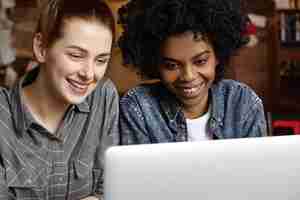 Foto grátis close-up de duas mulheres usando um laptop genérico juntas