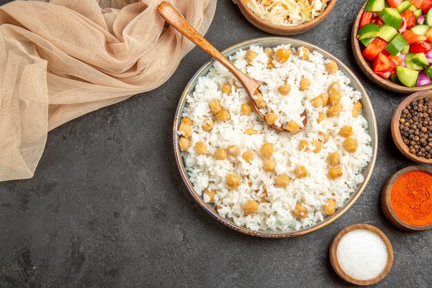 Close up de ervilhas e arroz prato para o jantar com uma colher e toalha de chucrute na mesa escura