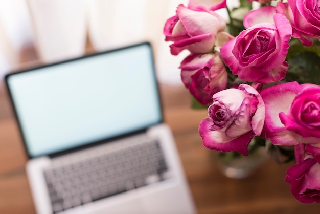 Close-up de flores com fundo laptop turva