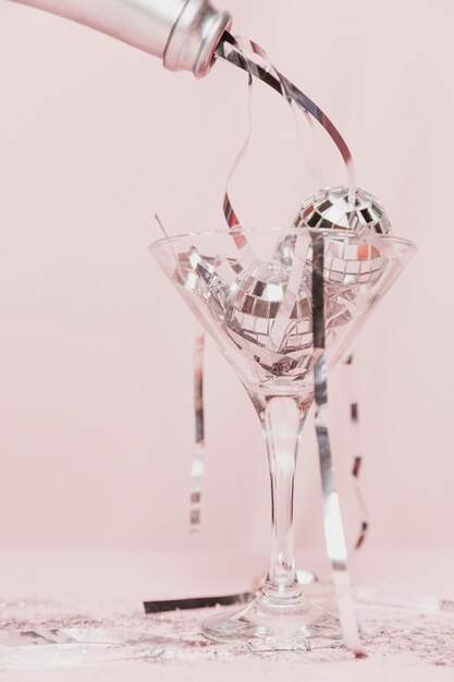 Close-up de garrafa de champanhe derramando ouropel em vidro