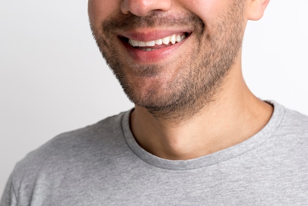 Foto grátis close-up, de, jovem, homem sorridente, em, cinzento, t-shirt, contra, fundo branco