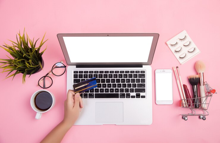 Foto grátis close-up de mão digitando em laptops que compraram cosméticos usando um cartão de crédito