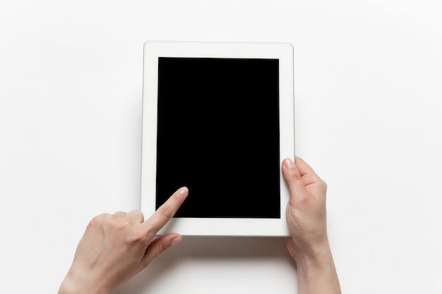 Close-up de mãos humanas usando tablet com tela preta em branco