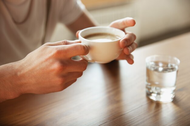 Close-up de mãos masculinas segurando a xícara de café, educação e conceito de negócio