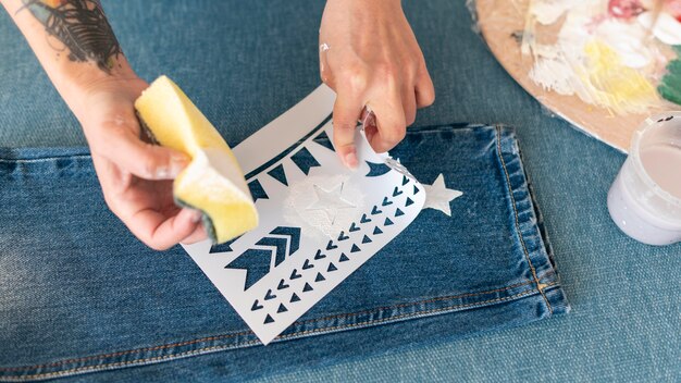 Foto grátis close-up de mãos pintando jeans