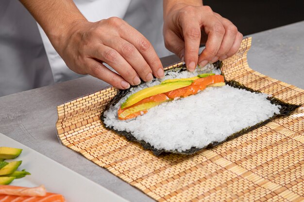 Close-up de mãos preparando sushi saboroso
