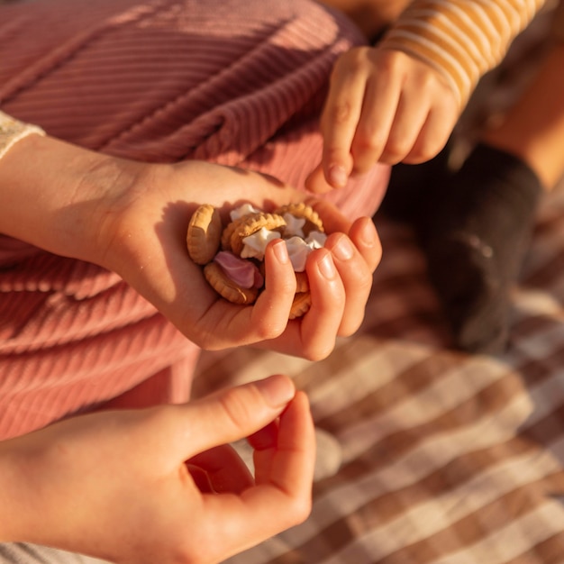 Foto grátis close-up de mãos segurando biscoitos saborosos