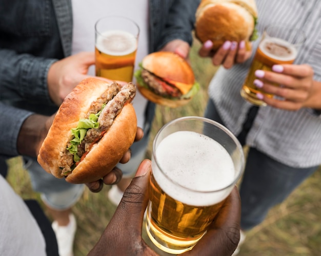 Close-up de mãos segurando comidas e bebidas