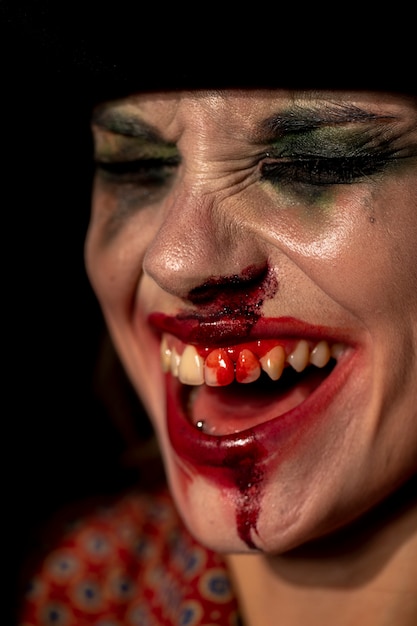 Close-up de maquiagem palhaço com sangue nos dentes
