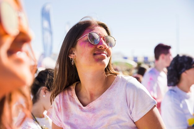 Close-up, de, mulher, desgastar, óculos de sol, tocando, com, holi, cor