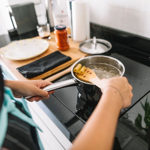 Foto grátis close-up, de, mulher, ferver, rigatoni, macarronada, ligado, fogão elétrico