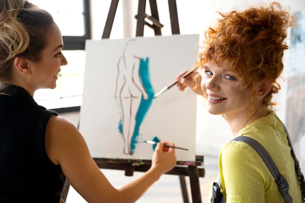 Foto grátis close-up de mulheres pintando na tela juntas