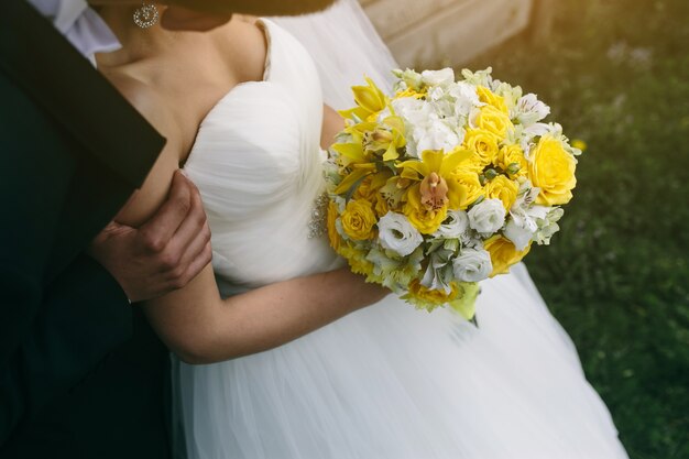 Close-up de noiva segurando um buquê de rosas