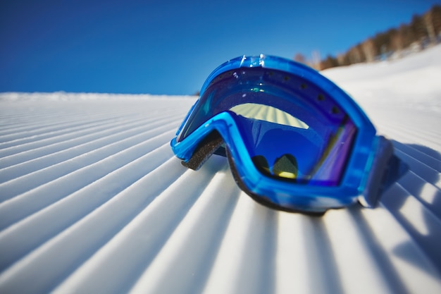 Close-up de óculos de snowboard na neve