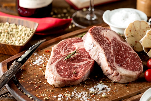 Close-up de pedaços de bife cru, guarnecido com sal e ervas