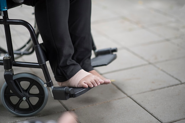 Close-up de pés idosos dor sentado na cadeira de rodas
