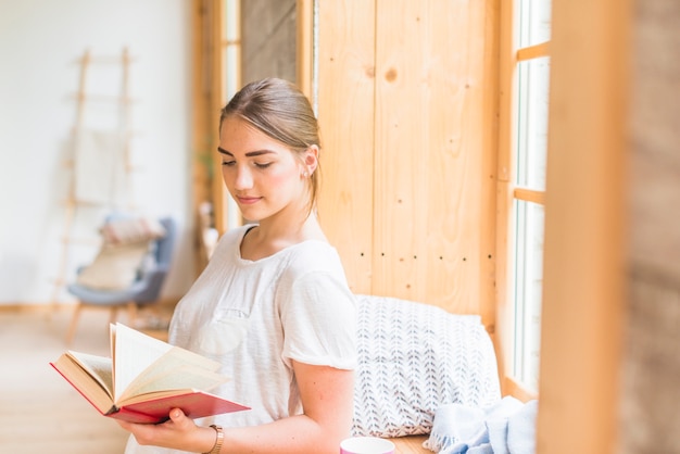 Close-up, de, posição mulher, perto, janela, livro leitura