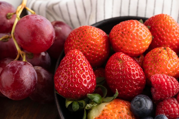 Foto grátis close-up de tigela com frutas e uvas