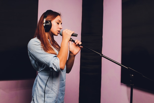 Close-up de um cantor gravando uma faixa em um estúdio.