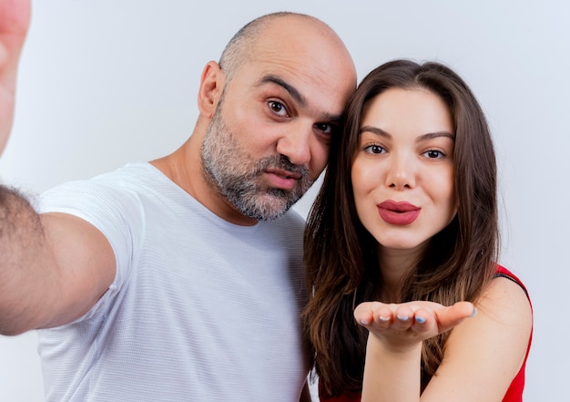 Close-up de um casal adulto satisfeito, homem estendendo a mão em direção a uma mulher mandando beijo