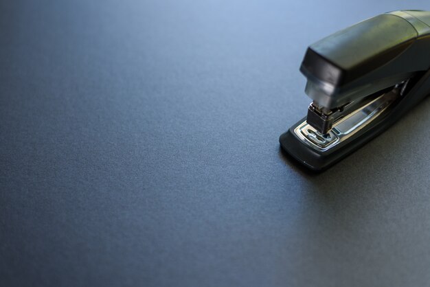 Close up de um grampeador isolado no fundo cinzento.