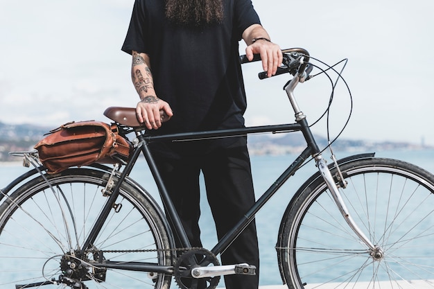 Foto grátis close-up, de, um, homem, com, tatuagem, ligado, seu, passe pé, com, bicicleta