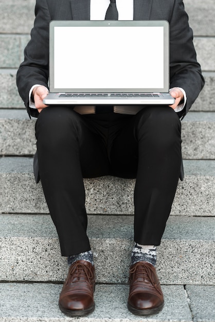 Foto grátis close-up, de, um, homem negócios, sentando, ligado, staircases, com, um, laptop aberto, sobre, seu, colo