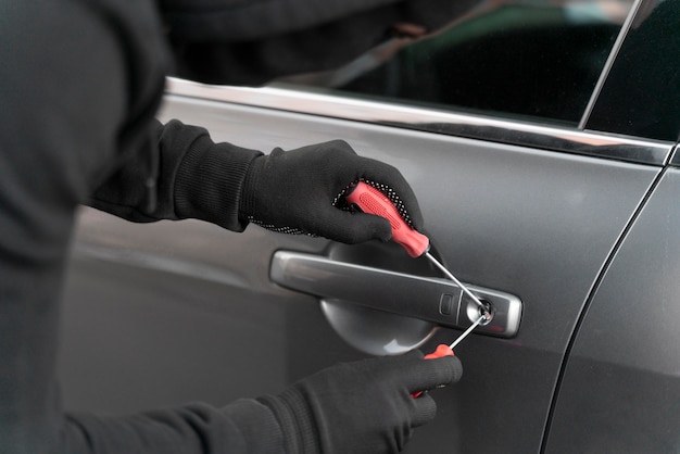 Foto grátis close-up de um homem tentando arrombar um carro