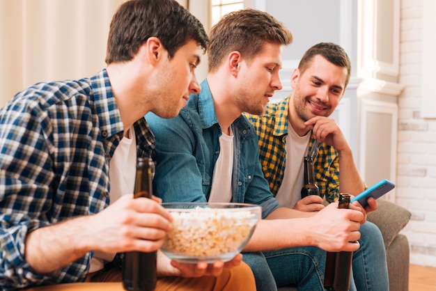 Close-up, de, um, homens jovens, sentar sofá, olhar, smartphone