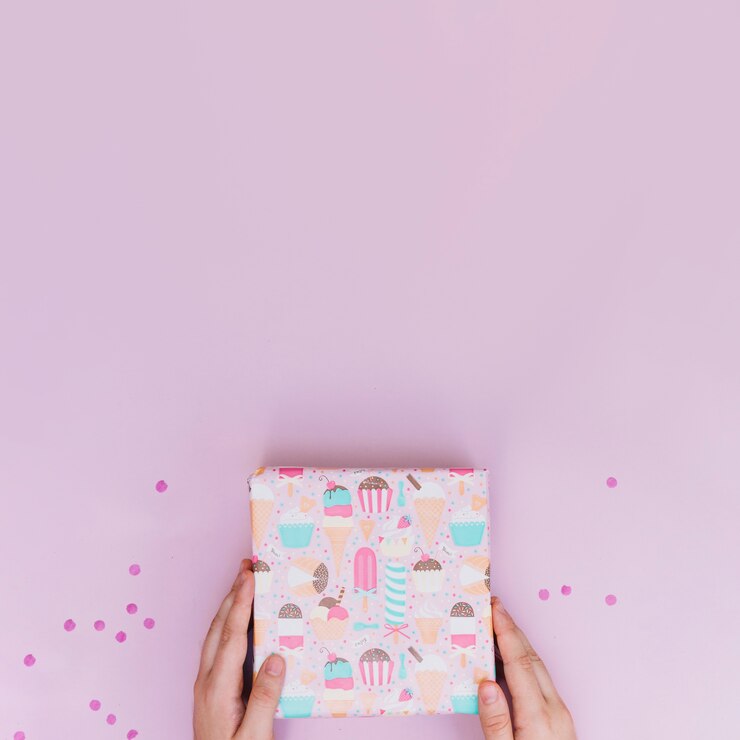 Foto grátis close-up, de, um, mãos, segurando, embrulhado, caixa presente, com, confetti, ligado, fundo cor-de-rosa