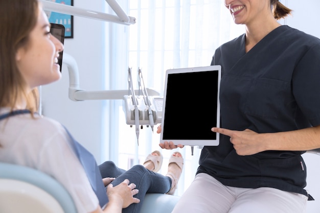 Close-up, de, um, odontólogo, apontar, ligado, tablete digital, tela, para, femininas, paciente