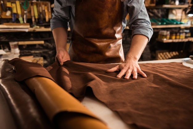 Close-up de um sapateiro trabalhando com têxteis de couro