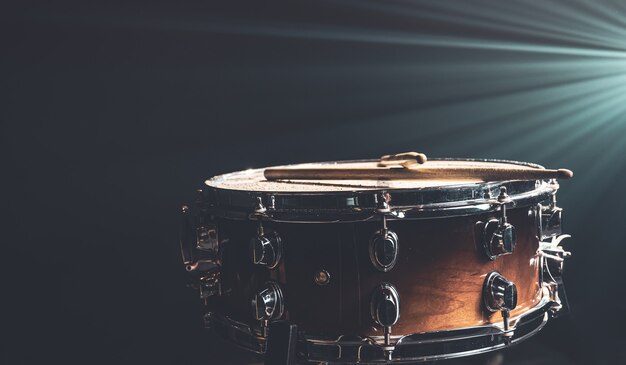 Close-up de uma caixa, instrumento de percussão em um fundo escuro com bela iluminação, copie o espaço.