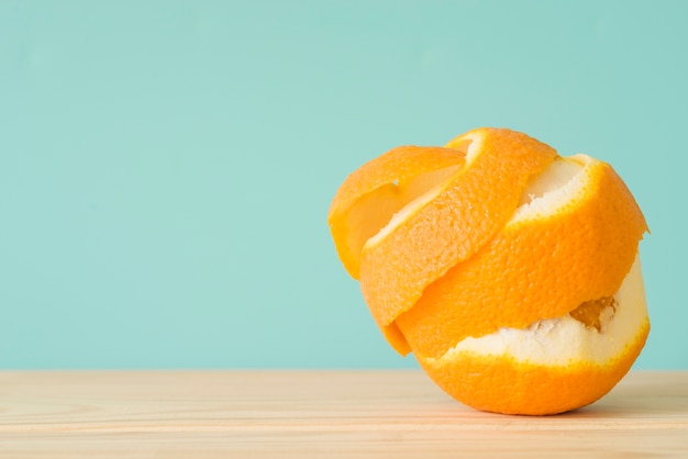 Close-up de uma fruta laranja descascada na superfície de madeira