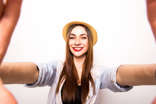 Foto grátis close-up de uma jovem mulher bonita tomando selfie. branco isolado