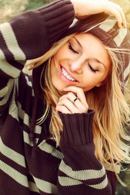 Close-up de uma mulher com um sorriso grande que veste uma camisa listrada