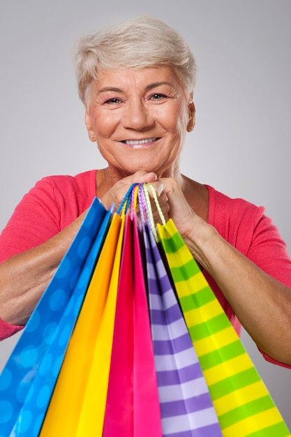 Close-up de uma mulher idosa com sacolas de compras