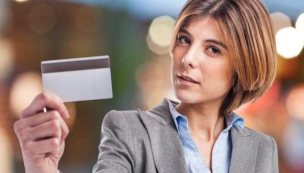 Close-up de uma mulher loira segurando um cartão de crédito