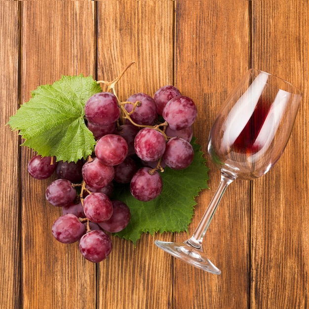 Foto grátis close up de uvas e copo de vinho vermelho