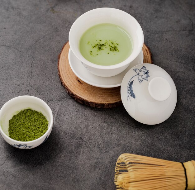 Close-up de xícara de chá matcha com batedor de bambu