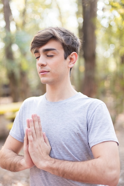 Close-up do adolescente meditando ao ar livre