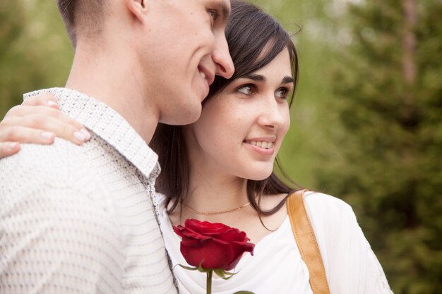 Close-up do casal sorridente com uma rosa